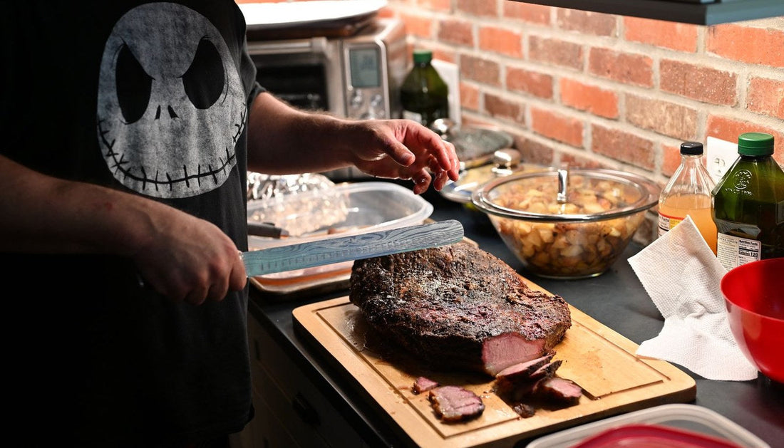 A cook slicing a roast on a large wooden cutting board in a home kitchen.