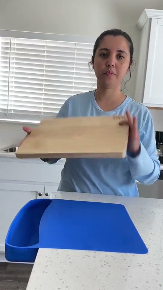 Home cook laying the ROO mat on the counter before chopping
