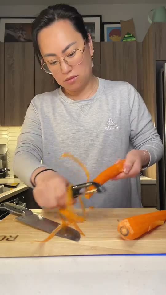 Home cook peeling potatoes on the ROO rubberwood cutting board for Japanese curry